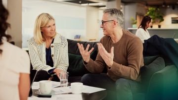 Mann und Frau unterhalten sich auf einem Sofa